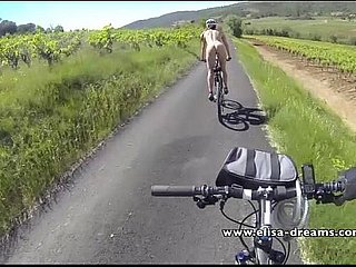 Мигание и обнаженные в общественной езде на велосипеде по дороге