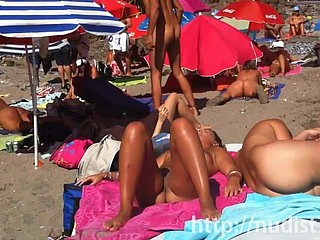 ビーチで自然の服装でセクシーなヌーディストの女性